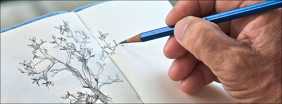 A man drawing at a desk after work